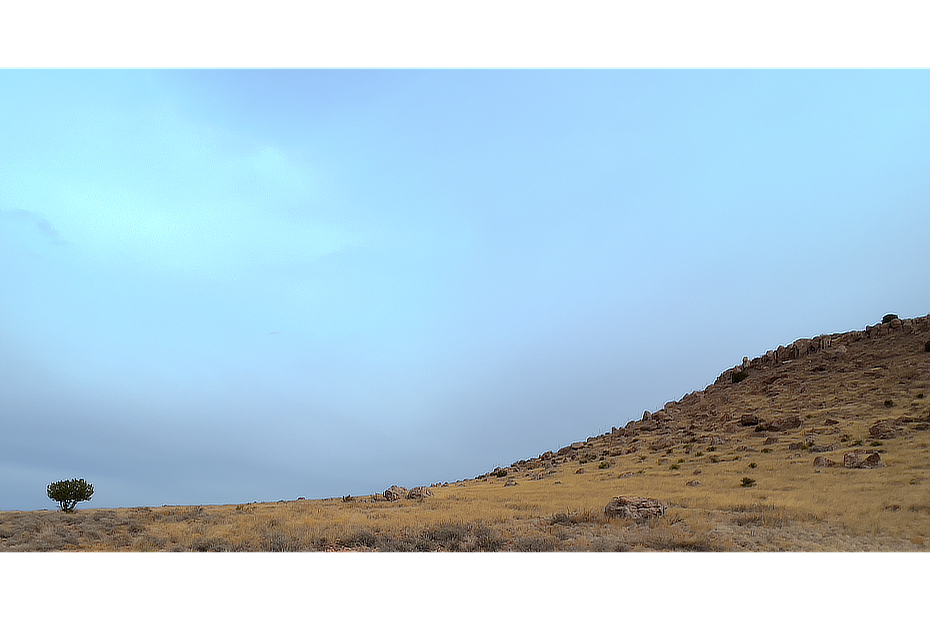 Clouds on an overcast day above a gently sloping high desert ground.