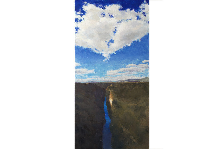 Bright white clouds above the Rio Grande Gorge with a spot of bright sunlight in the shadow area of the rocky wall as seen from the bridge in Taos, New Mexico.